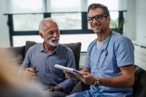 Smiling male doctor discussing test results with an older male patient.
