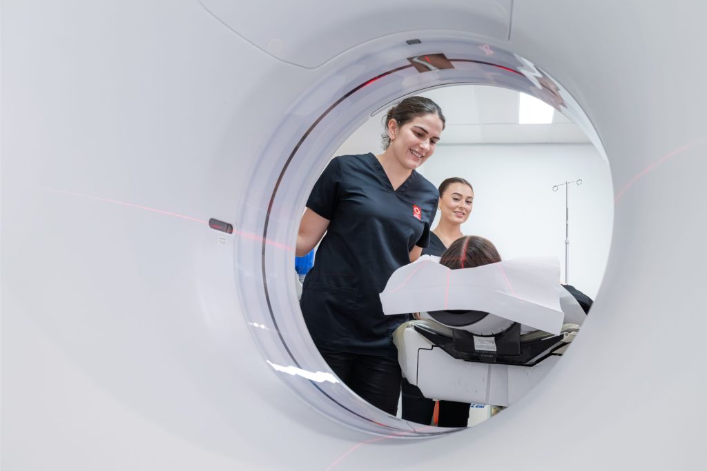 CT Radiographer cares for patients as she enters CT scanner tunnel